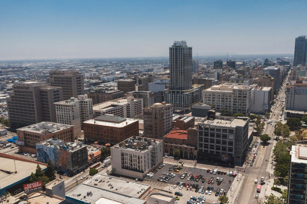Panoramic aerial shot capturing downtown Los Angeles with skyscrapers and urban streets.