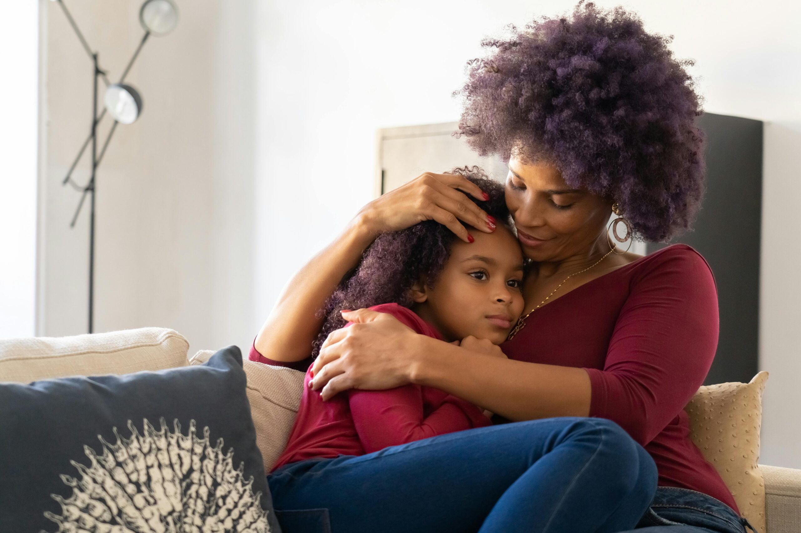 Warm embrace between mother and daughter, conveying love and comfort indoors.